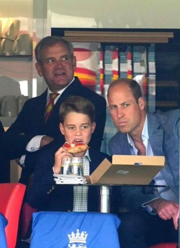 Prince George of Wales eating his pizza while his dad