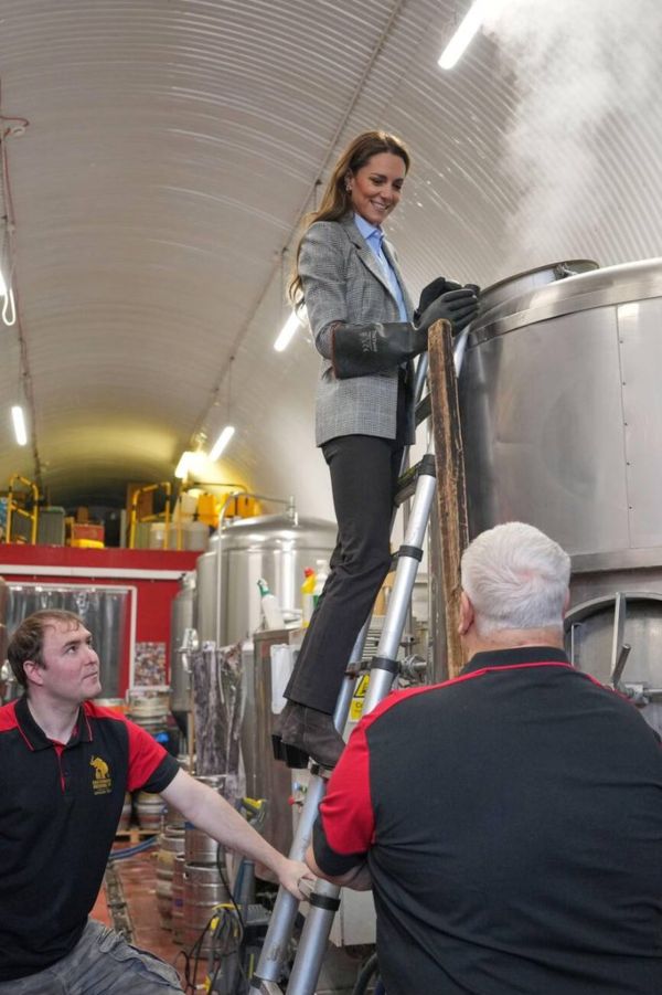 The Princess of Wales checks a brewhouse kettle as she tours the brewery during a visit of the